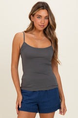 woman wearing a dark gray tank top with thin straps and styled with blue shorts