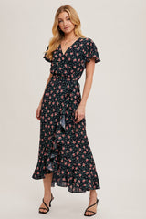 woman wearing a black floral wrap dress with ruffle details and short sleeves