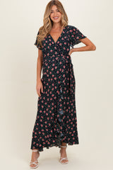 woman wearing a navy floral wrap maternity dress with short sleeves and a ruffle hem, showcasing her baby bump
