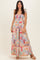 woman wearing a multicolor patterned maxi dress with shoulder ties and a tiered skirt