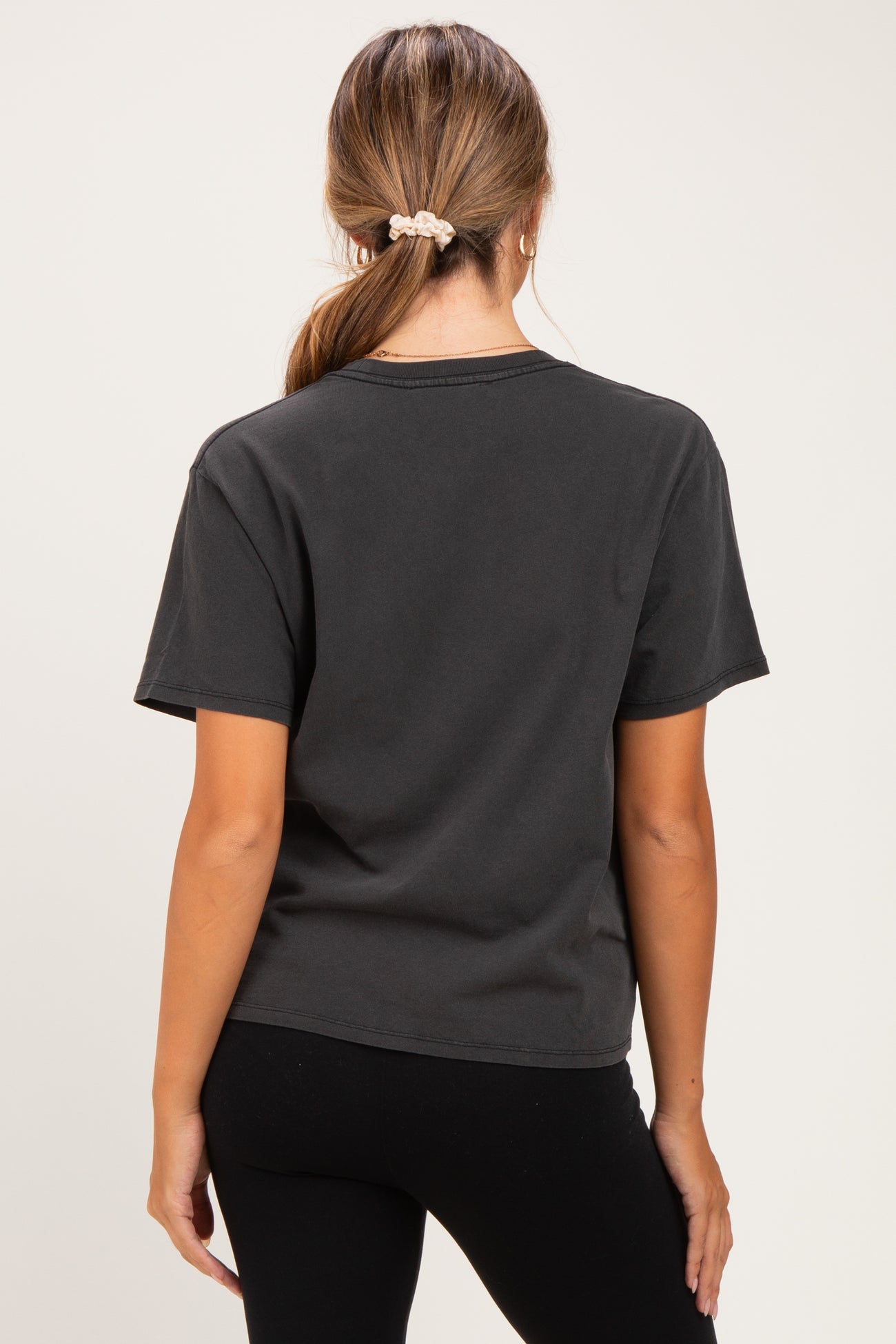 woman wearing a dark gray short sleeve maternity t-shirt with a relaxed fit, viewed from the back