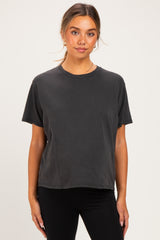 woman wearing a black short sleeve maternity top with a relaxed fit and round neckline
