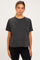 woman wearing a black short sleeve maternity top with a relaxed fit and round neckline