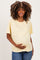 woman wearing a light yellow oversized maternity t-shirt and holding her baby bump