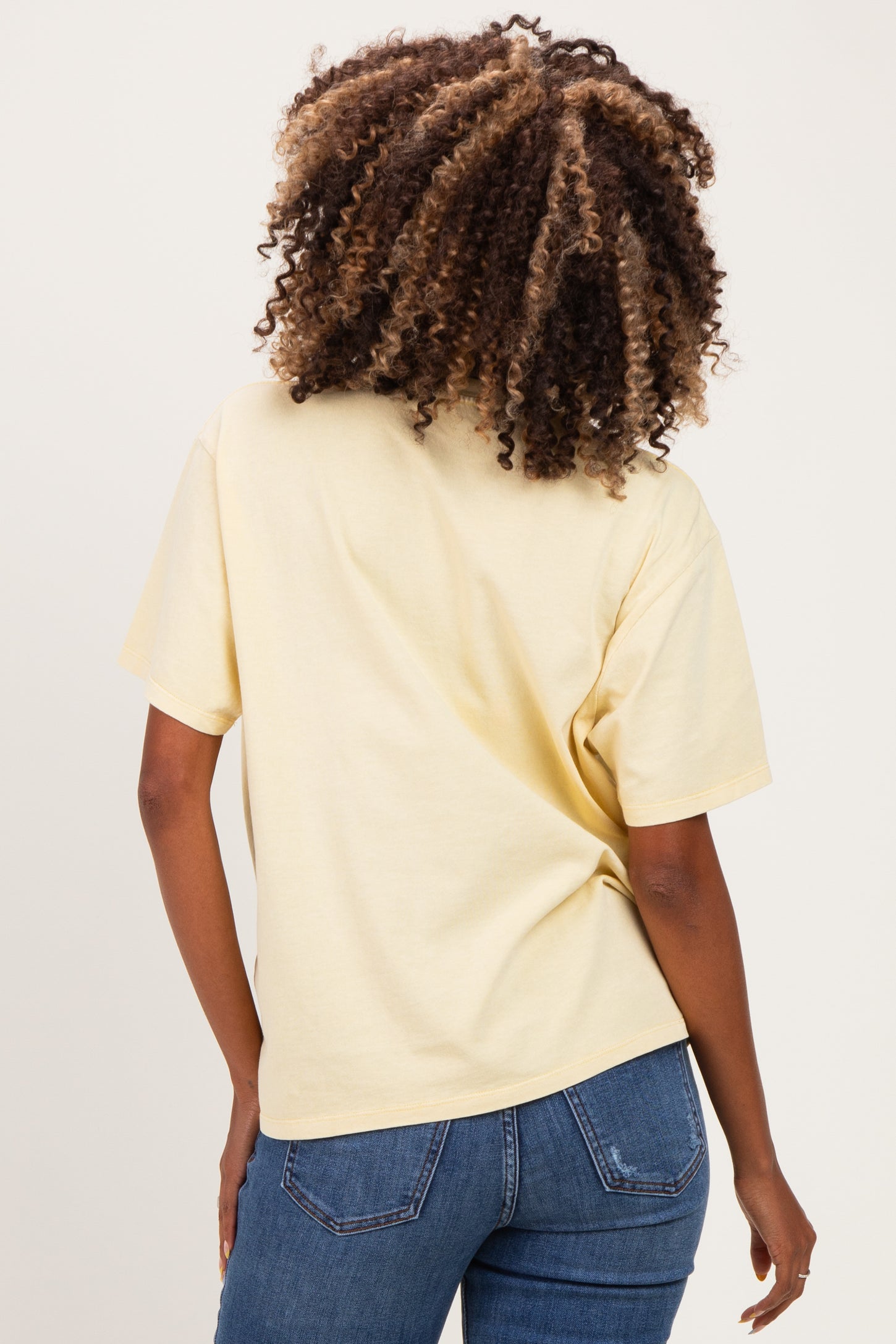 woman wearing a yellow short sleeve maternity top with a relaxed fit and back view, paired with jeans
