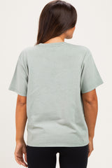 woman wearing a light green oversized maternity t-shirt from the back, paired with black leggings