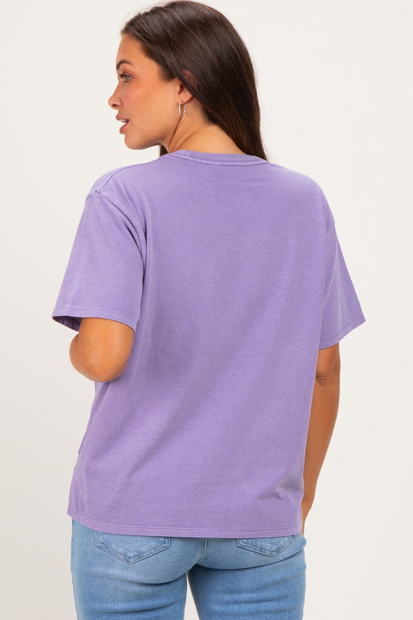 woman wearing a relaxed fit lavender maternity t-shirt, showing the back view, paired with light blue jeans