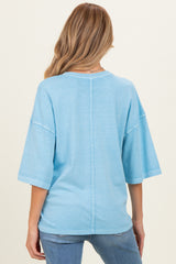 woman wearing a light blue oversized maternity top with a relaxed fit and back seam detail