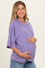 woman wearing a purple oversized maternity t-shirt and holding her baby bump