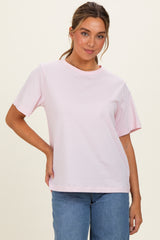 woman wearing a pink short sleeve t-shirt paired with blue jeans