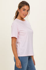 woman wearing a light pink short sleeve t-shirt and blue jeans
