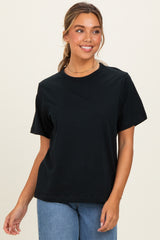 woman wearing a black short sleeve t-shirt paired with high-waisted light blue jeans.