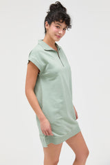 woman wearing a light green short-sleeve polo dress with a zip collar and relaxed fit