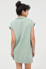 woman wearing a green short sleeve polo dress, seen from the back