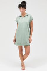 woman wearing a light green zip-up short sleeve dress with a relaxed fit