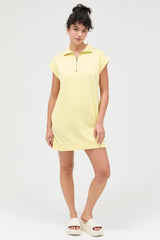 woman wearing a yellow zip-up short sleeve dress and white slide sandals