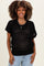 woman wearing a black open-knit maternity sweater with short sleeves and a relaxed fit, smiling at the camera