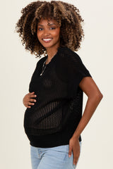 woman wearing a black knitted maternity top and holding her baby bump