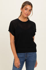 woman wearing a black short sleeve knitted sweater paired with blue jeans