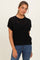 woman wearing a black short sleeve knitted sweater paired with blue jeans