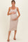 woman wearing a beige ribbed maternity dress and holding her baby bump