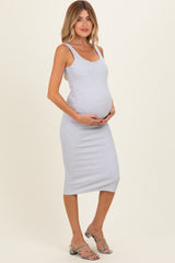 woman wearing a light gray maternity knit tank dress and holding her baby bump