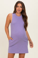 woman wearing a lavender sleeveless maternity dress with pockets and a visible baby bump