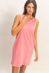 woman wearing a sleeveless coral pink dress with a relaxed fit and round neckline