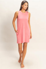 woman wearing a pink sleeveless dress with pockets and a relaxed fit