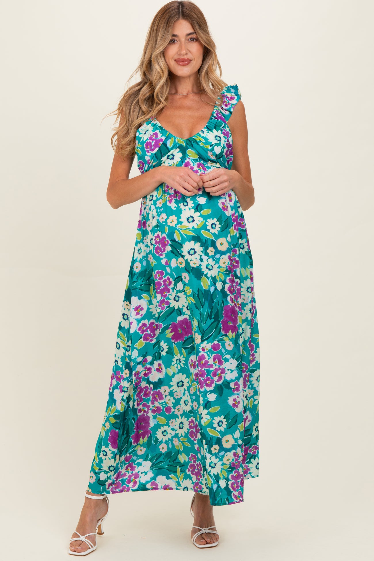 woman wearing a floral maternity maxi dress with ruffle straps and a baby bump visible