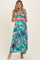 woman wearing a floral maternity maxi dress with ruffle straps and a baby bump visible