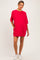 woman wearing a bright pink oversized maternity dress with short sleeves and side pockets