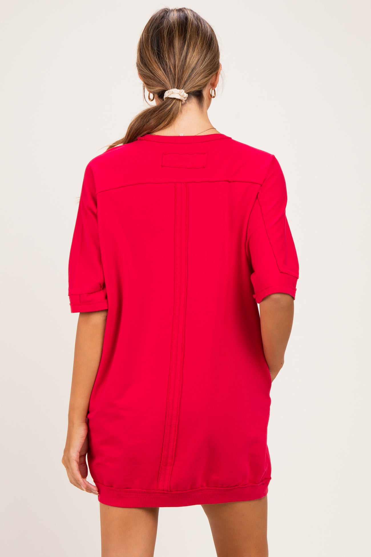 woman wearing a bright red maternity dress with short sleeves and a relaxed fit