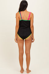 woman wearing a black ribbed swimsuit with colorful straps and a low-cut back