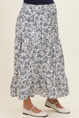 woman wearing a navy floral maternity maxi skirt with tiered ruffles