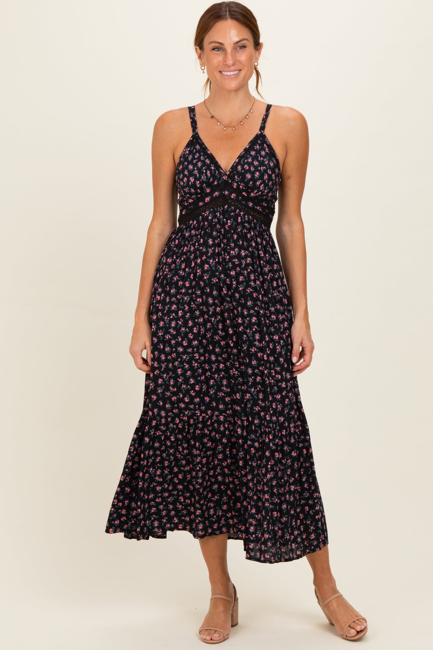 woman wearing a black floral maxi dress with spaghetti straps and a tiered hem