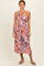 woman wearing a floral midi dress with a crisscross bodice and adjustable straps in pink and blue hues