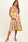 woman wearing a floral maternity dress with a halter neck and a baby bump visible