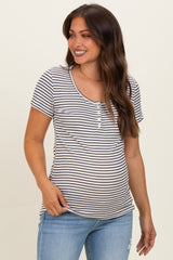 woman wearing a striped maternity t-shirt with short sleeves and a scoop neckline, highlighting her baby bump