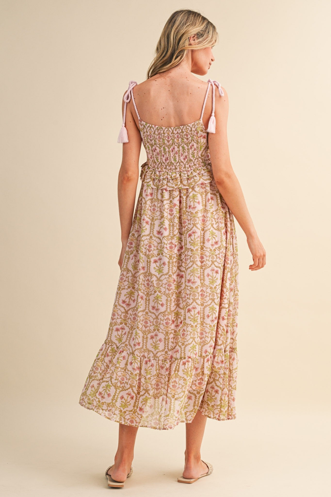 woman wearing a pink and green floral maxi dress with smocked bodice and tie straps