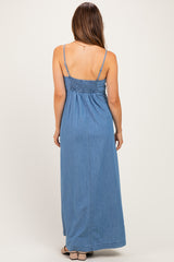 woman wearing a denim maxi maternity dress with smocked back and adjustable straps, viewed from the back