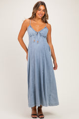 woman wearing a light blue maternity maxi dress with adjustable straps and a tie detail at the bust, showing her baby bump