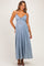 woman wearing a light blue maternity maxi dress with adjustable straps and a tie detail at the bust, showing her baby bump