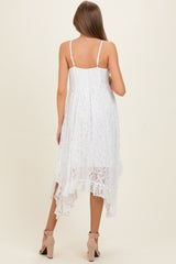 woman wearing a white lace maternity dress with a high-low hem and adjustable spaghetti straps