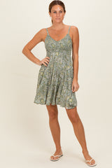 woman wearing a green floral print sundress with adjustable straps and a flowy skirt