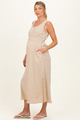 woman wearing a beige and white striped maternity maxi dress with pockets and a visible baby bump
