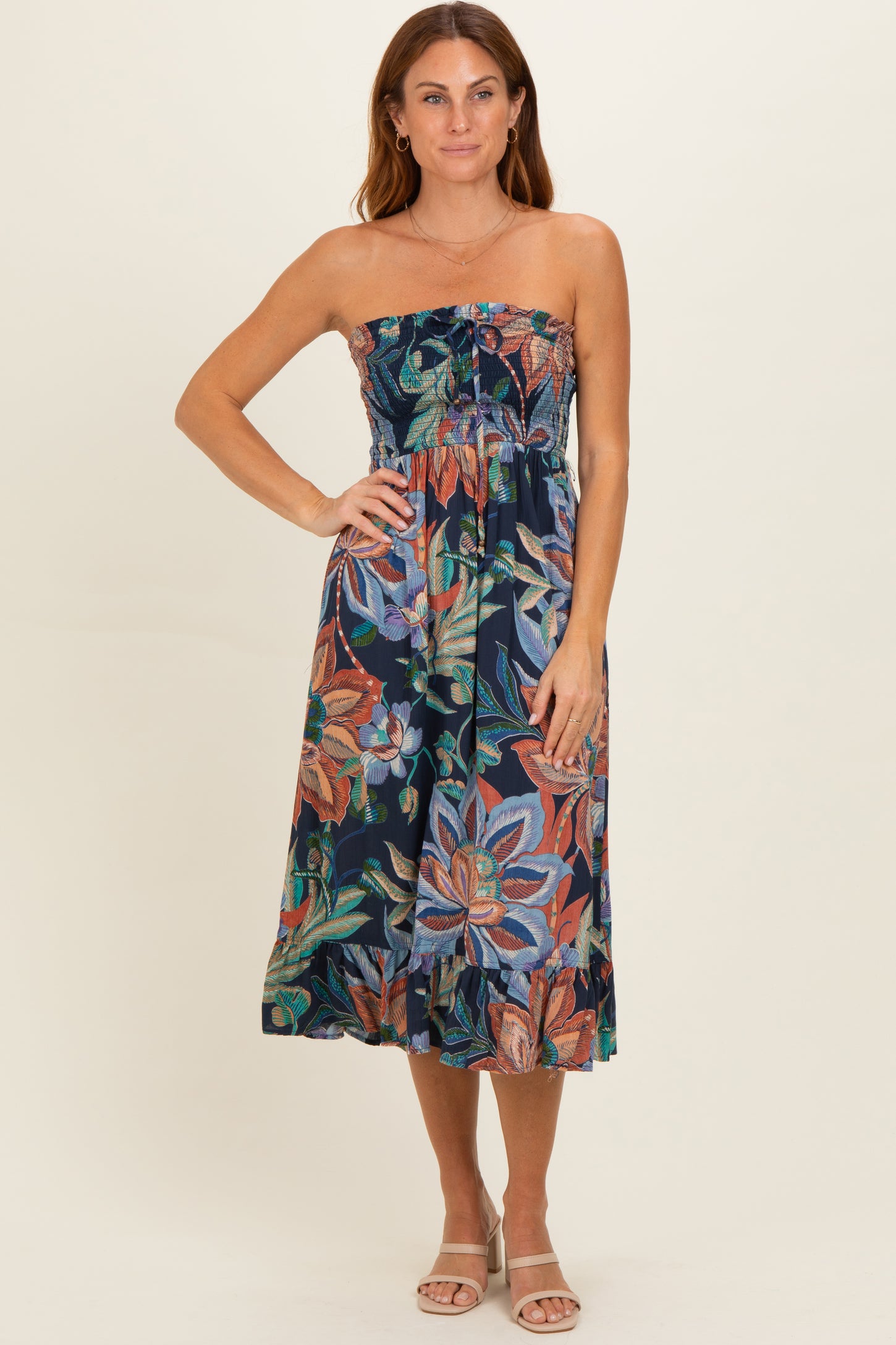 woman wearing a strapless floral print midi dress with a fitted bodice and flowy skirt