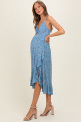 woman wearing a blue floral maternity dress with a v-neckline and ruffled hem, showcasing her baby bump