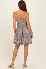woman wearing a back view of a floral print sundress with adjustable spaghetti straps and a flared skirt