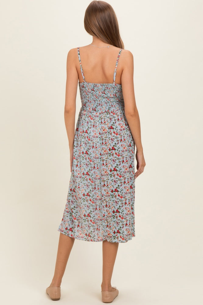woman wearing a floral maternity dress with spaghetti straps and a smocked back, showing a flowy, mid-length style